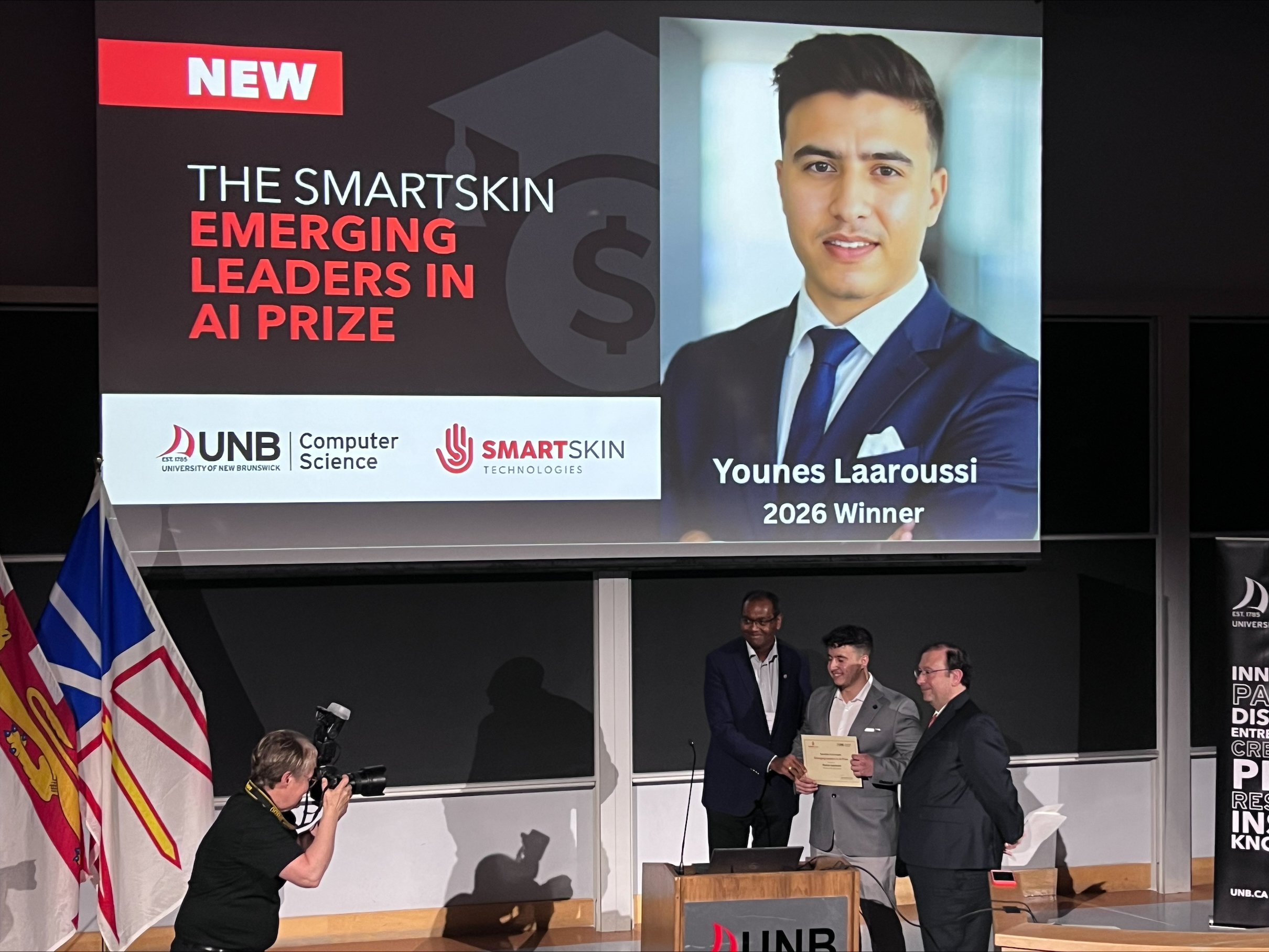 Younes Laaroussi receiving the SmartSkin Emerging Leaders in AI Prize certificate on stage at the Atlantic AI Summit.